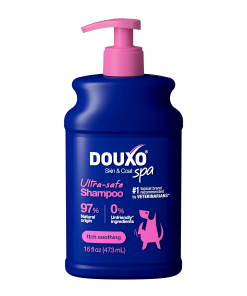 The front of a 16 fl oz bottle of DOUXO Itch Soothing Shampoo for dogs, featuring a dark blue bottle with a light pink pump dispenser and pink label accents.